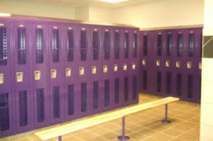 Purple locker room at New Town High School with wooden bench seat in foreground.