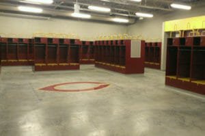Maroon and Gold sports lockers with concrete floor and C for Concordia logo underneath.