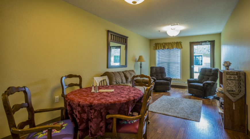 Combo living and dining room space with beige walls, wooden floors and furniture throughout.