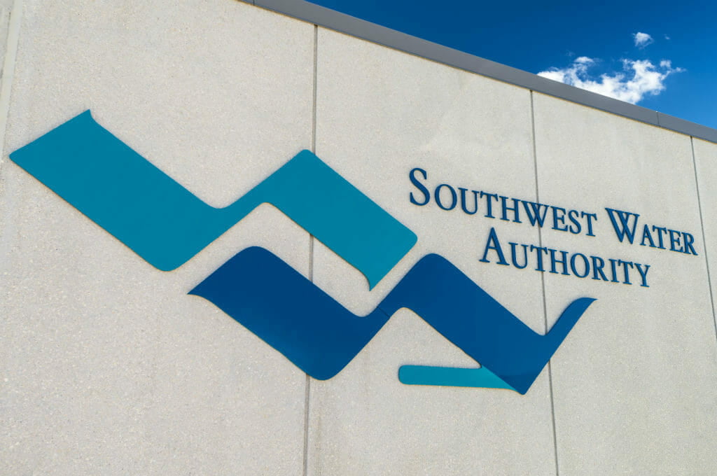 Exterior stucco beige wall with Southwest Water Authority blue logo