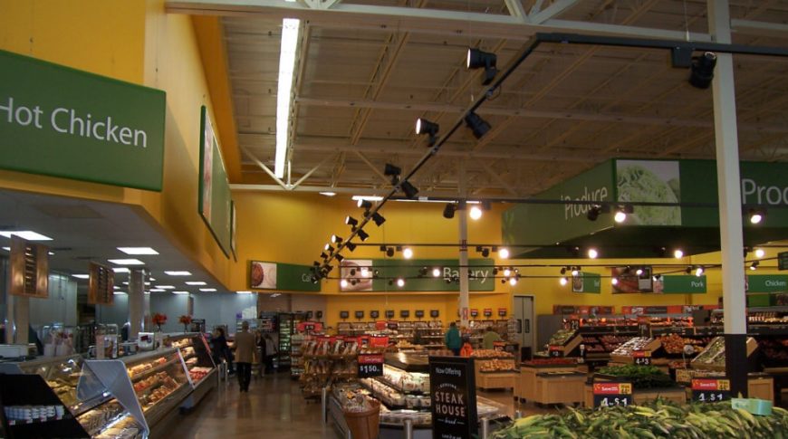 Grocery view of produce section with bakery section in the far back and meat section to far right with deli in upper left corner