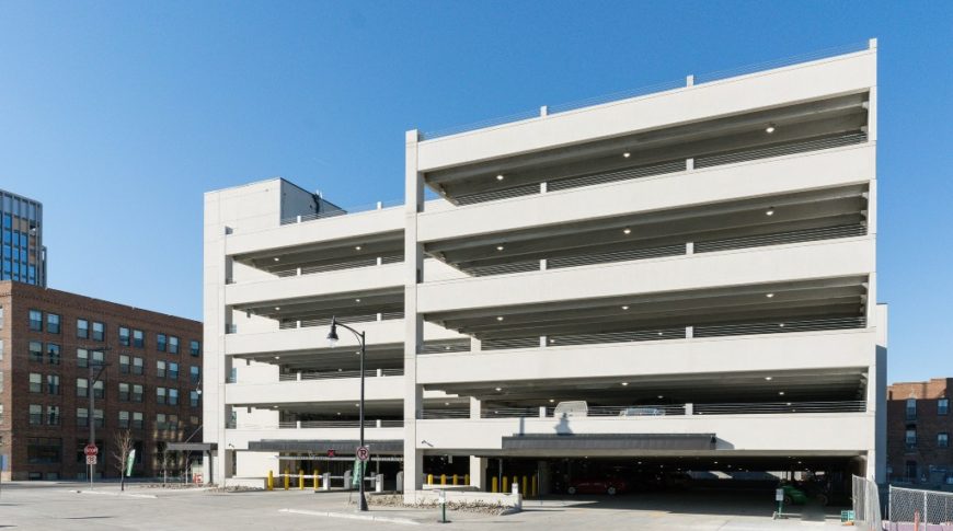 Exterior view of 6-story parking ramp and ground entrances from across the street.