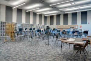 Two-story tall band room with chairs and music pedestals throughout with percussion instruments in the back row.