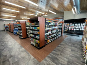 Interior view of Cenex C-Store liquor store with liquor isles down the center, coolers in the rear and vaulted pine planked ceiling overhead.