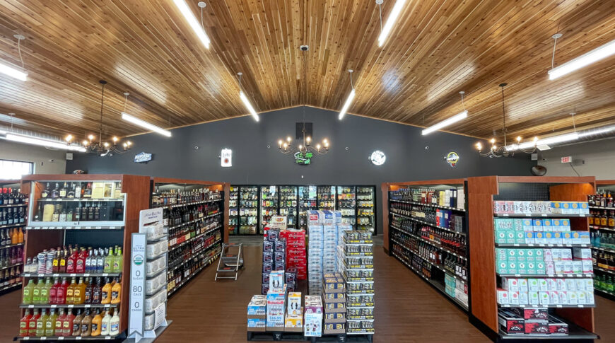 Cenex C-Store liquor store viewpoint in front of isles looking down the rows of liquor with coolers in the background and pine wooden planked vaulted ceiling overhead.